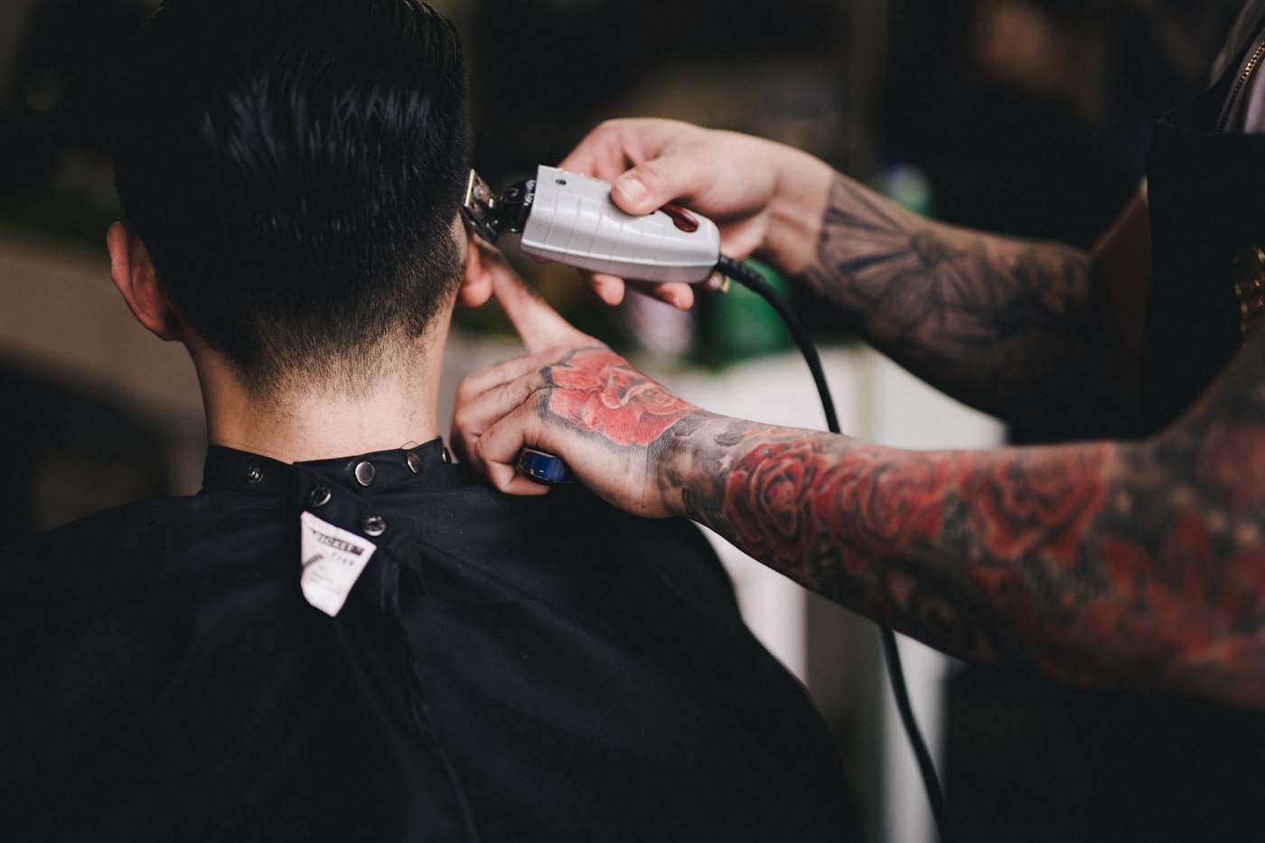 A barber using clippers to finish a neckline